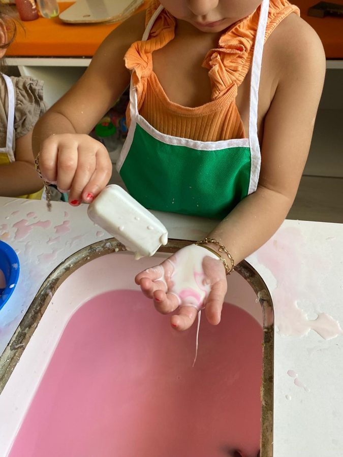 Çocuk, pembe leğene köpük sıkıyor